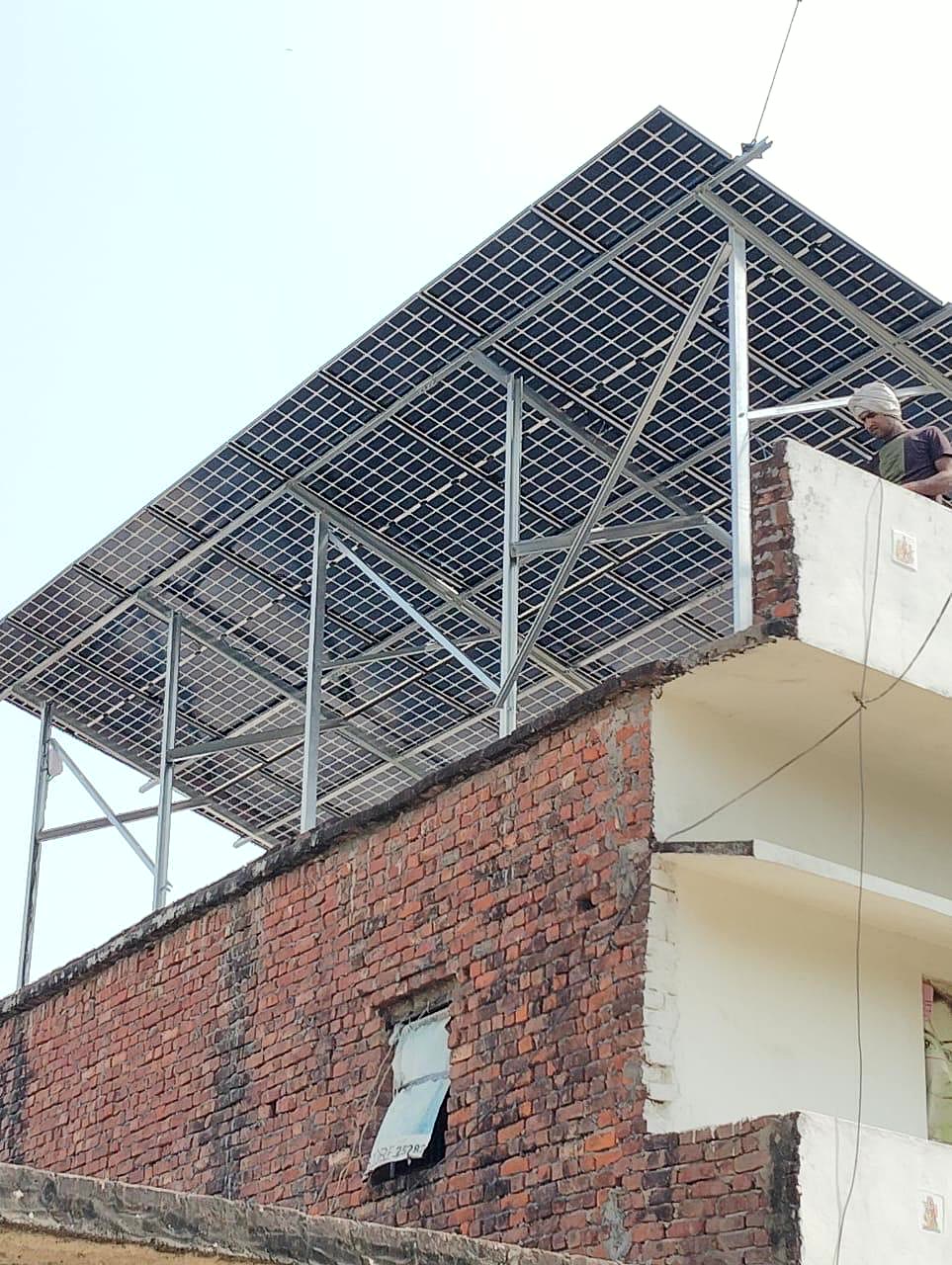 Tilted rooftop solar panel array mounted on a brick building